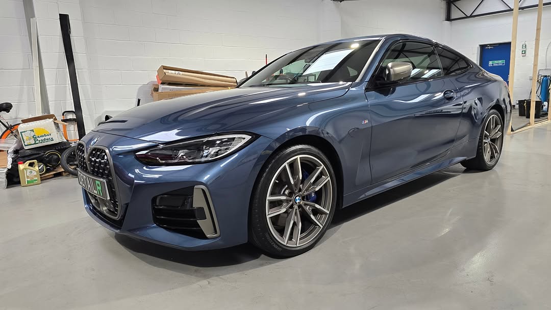Blue BMW sedan polished in garage
