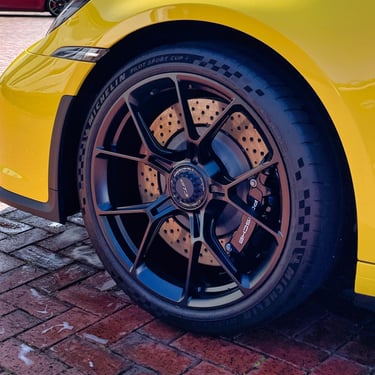 Yellow sports car wheel and brake calipers detail